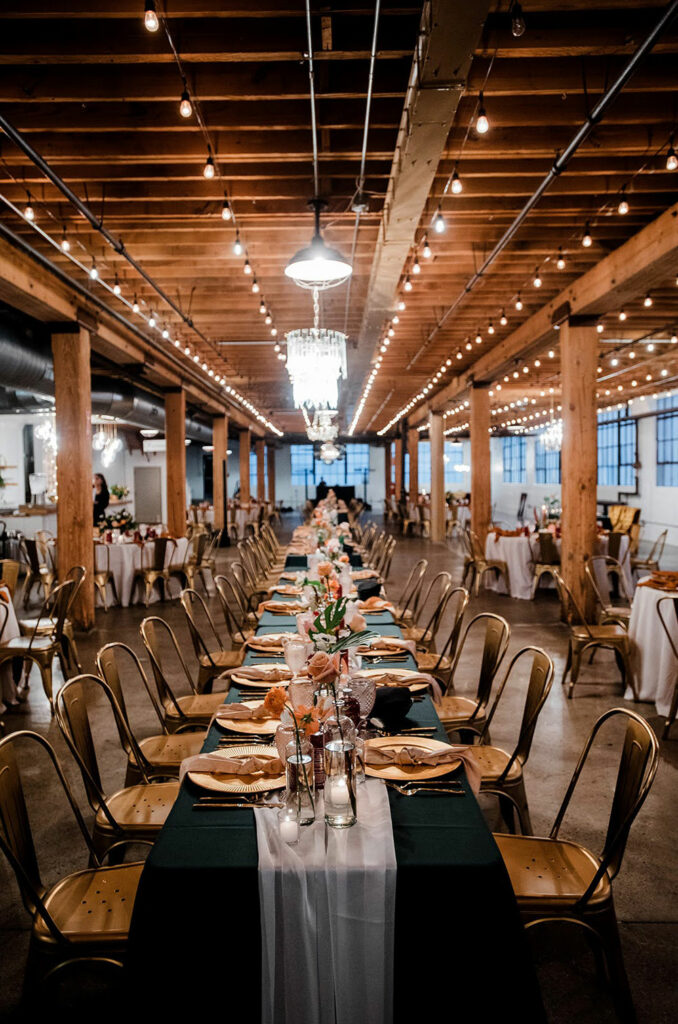 Long table with floral at industrial wedding venu.